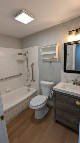 a bathroom with a toilet and a tub and a sink at Serene home in Simi valley, CA in Simi Valley