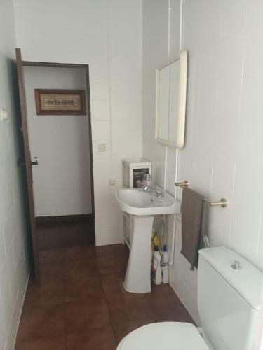 a white bathroom with a sink and a toilet at Casa Deocano in Fuenteheridos