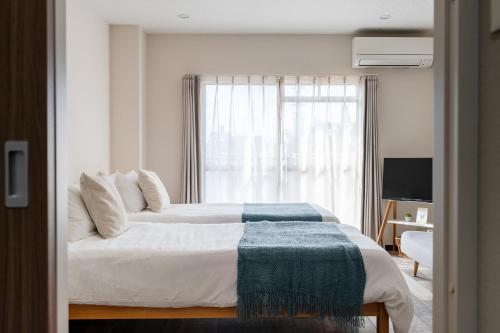 a bedroom with two beds and a window at Planetarium N in Yamashitachō
