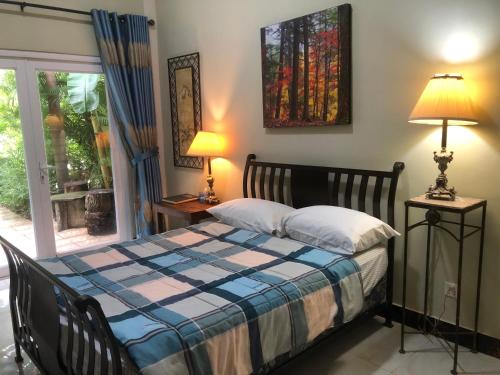 una camera da letto con un letto con una coperta blu e bianca di B&B Verger Vannary a Phumĭ Băk Chĕnhchiĕn