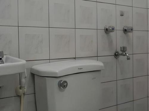 a white bathroom with a toilet and a sink at Hotel Sogo Tarlac in Suizo