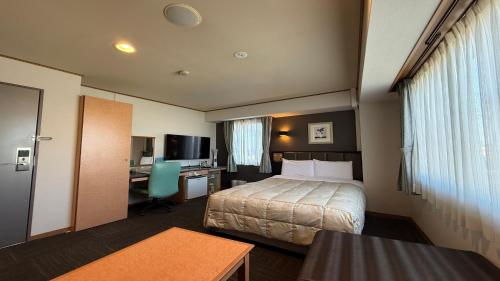 a hotel room with a bed and a desk at Suzuka Storia Hotel in Suzuka