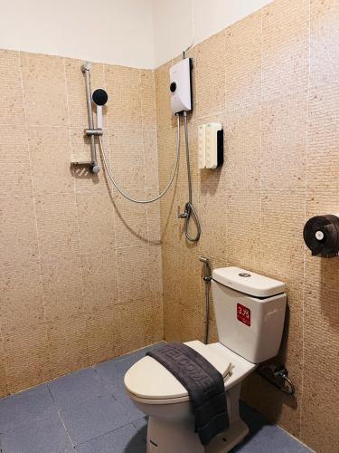 a bathroom with a toilet and a shower at Lanta Nesta Resort in Ko Lanta Yai