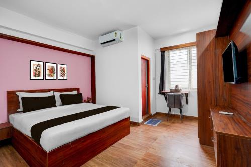 Un dormitorio con una cama y un televisor de pantalla plana. en Super Townhouse Whitefield Railway Station Formerly Kadugudi Whitefield, en Bangalore