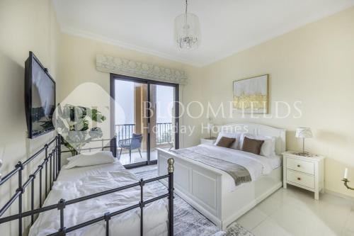 Un dormitorio con una cama y un balcón. en Bloomfields Delux 2BR Miad Town House Mina, en Rūl Ḑadnā