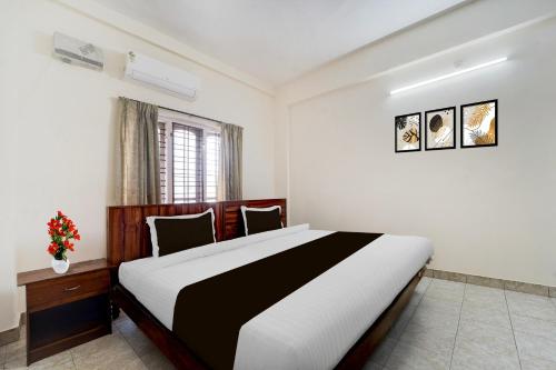 a bedroom with a large bed in a room at Super Hotel O Pathanamthitta Near Mahatma Gandhi Statue in Pathanāmthitta