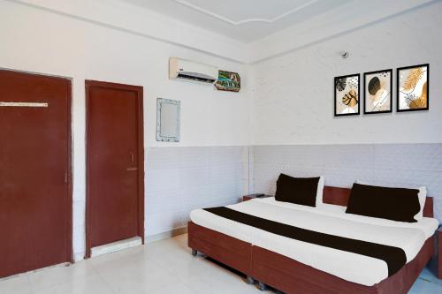 a bedroom with a large bed in a room at Hotel O Shilpgram Taj Mahal East Gate in Agra