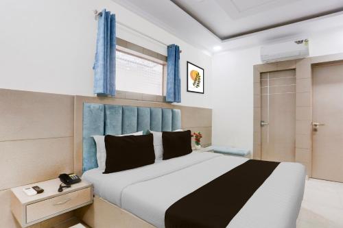 a bedroom with a large bed with a blue headboard at Super Hotel O Heera Nagar Formerly Cosy stay in Haldwāni