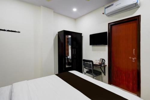 a bedroom with a bed and a desk and a door at Collection O Adibatla X Road, Near TCS, Wonderla Road in Ibrāhīmpatan