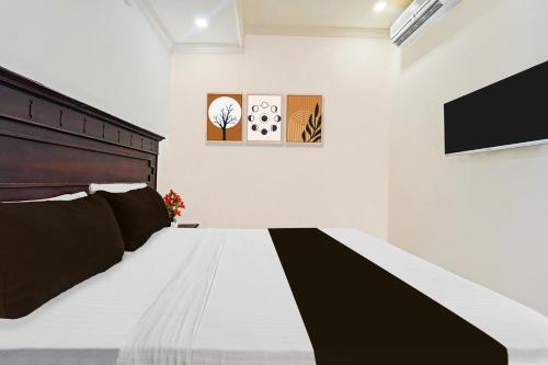 a bedroom with a black and white bed and a tv at Hotel O Padma Junction MG Road in Cochin