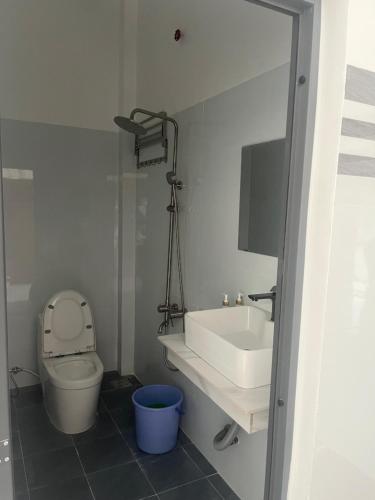 a white bathroom with a sink and a toilet at Nhà Nghỉ Phát Thành in Trà Vinh