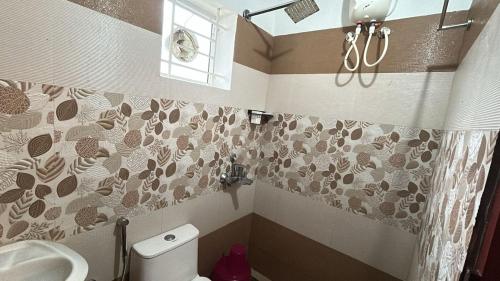 een badkamer met toilet en wastafel bij Le divine in Guruvāyūr