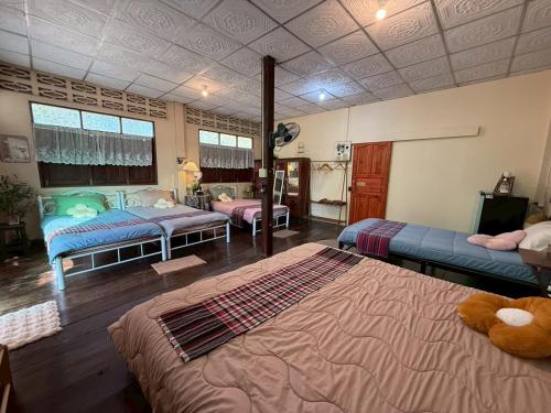 a bedroom with two beds in a room at บ้านสวนชายน้ำ โฮมสเตย์ อัมพวา in Ban Nong Chaeng
