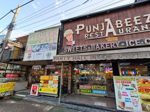 una tienda con letreros al lado de un edificio en Punjabeez Restaurant, en Patiala