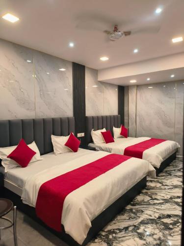 two beds in a hotel room with red pillows at Punjabeez Restaurant in Patiāla