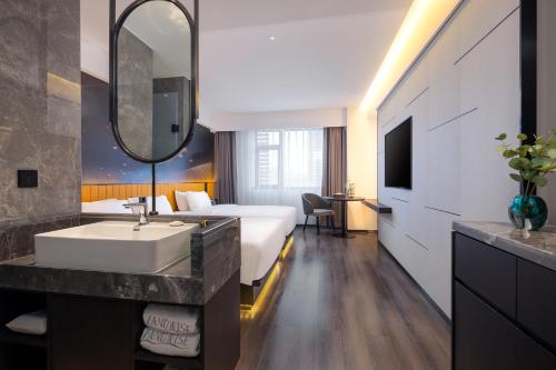 a hotel room with a bed and a sink at Landwise in Haikou
