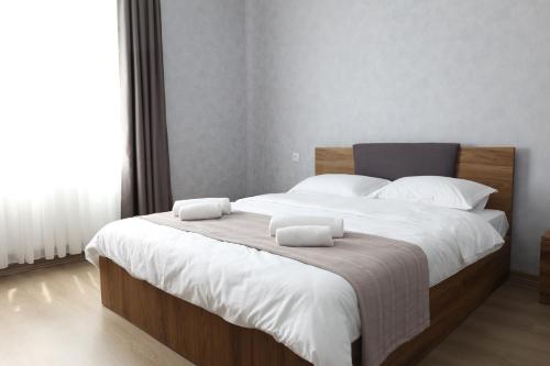 a large bed with two white pillows on it at guesthause Tba Inn in Borjomi