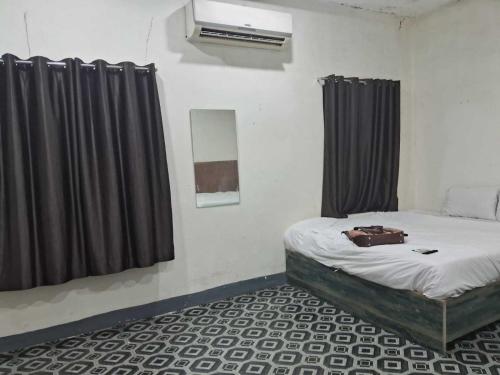 a room with a bed with curtains and a bag on it at Hotel O Smriti Villa in Ballygunge