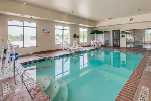 a large swimming pool with blue water in a building at Wingate by Wyndham New Braunfels in New Braunfels