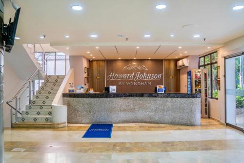 a lobby of a store with a counter and stairs at Howard Johnson by Wyndham Barranquilla Versalles in Barranquilla