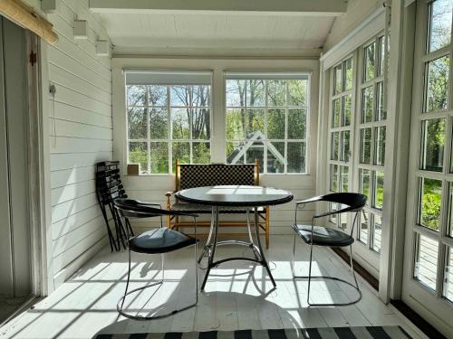a screened in porch with a table and chairs at Villa Betula Nature Gem At Hårbølle Harbor in Askeby