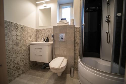 Un baño con inodoro, lavabo y bañera. en Sweet Escape in Rakvere Center, Perfect for Two, en Rakvere