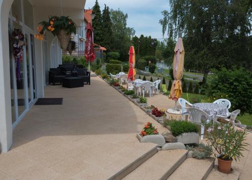 a patio with tables and chairs and umbrellas at Napkelte Vendégház in Orfű