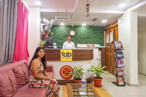 a woman sitting on a couch in front of a counter at FabHotel Shree Swami, Nr Bird Valley Udyan in Pune