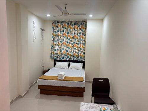 Un dormitorio pequeño con una cama y una ventana. en Hotel O Elegance Inn, en Sopāra