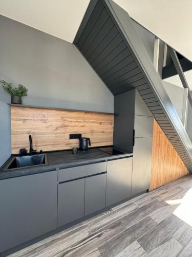 an attic kitchen with a sink and a staircase at Двухуровневая квартира в центре in Kharkiv