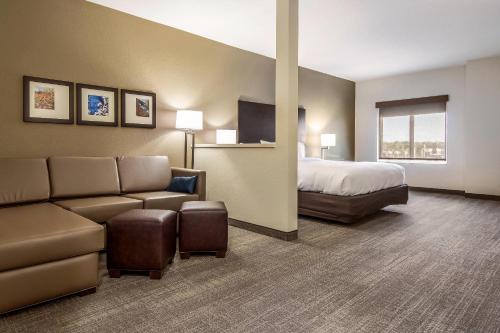 a hotel room with a bed and a couch at Comfort Suites Brunswick - Cleveland Southwest in Brunswick