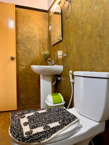 a bathroom with a toilet and a sink at Cozy Heaven in Nuwara Eliya