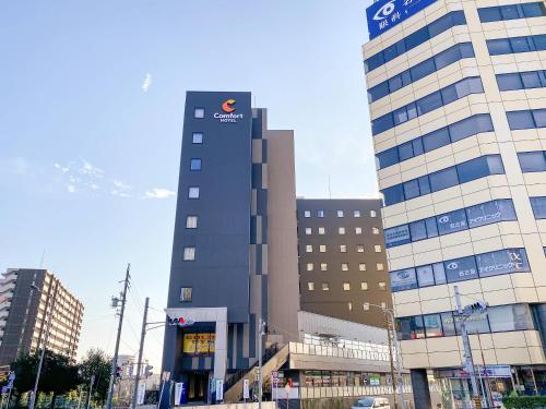 a tall building with a sign on the side of it at Comfort Hotel Nagoya Kanayama in Nagoya