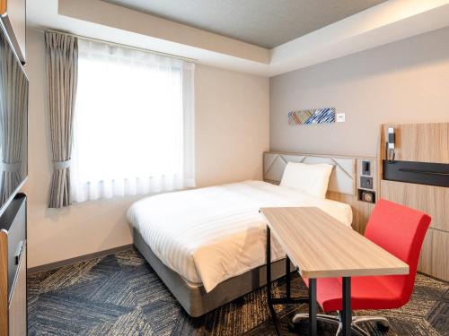 a hotel room with a bed and a table at Comfort Hotel Nagoya Kanayama in Nagoya