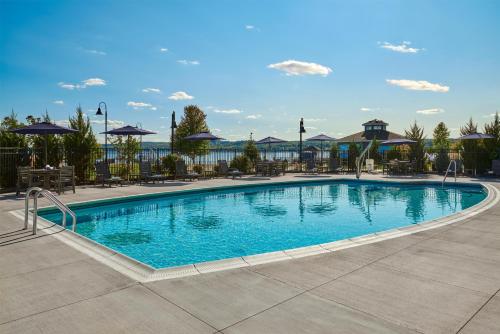 a swimming pool at a resort with tables and umbrellas at Hotel Canandaigua, Tapestry Collection By Hilton in Canandaigua