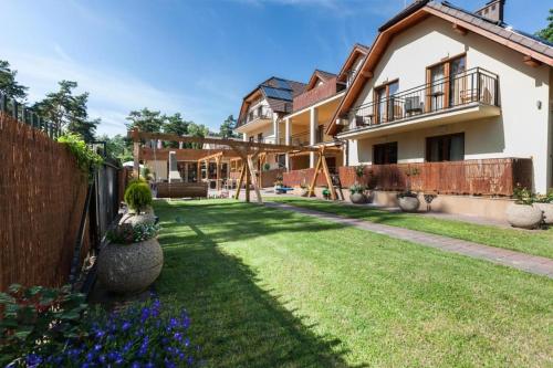 a yard with a fence and a house at Paula Wellness & SPA in Pobierowo
