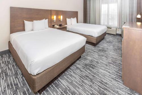 a hotel room with two beds and a desk at Country Inn & Suites by Radisson, Smyrna - Atlanta Northwest in Smyrna