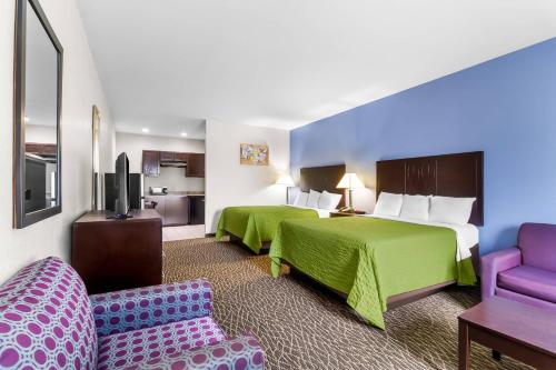 ein Hotelzimmer mit zwei Betten und einer Couch in der Unterkunft Econo Lodge in Bryan