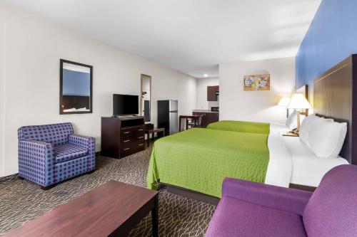 a hotel room with a green bed and a chair at Econo Lodge in Bryan