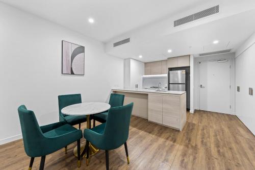a kitchen and dining room with a table and chairs at Lucid Apartments by CLLIX in Brisbane