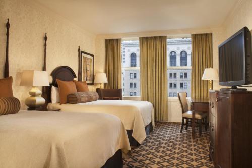 a hotel room with two beds and a flat screen tv at Omni San Francisco in San Francisco