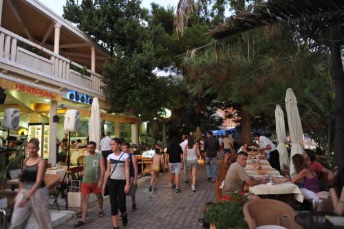 a group of people walking down a street with tables at Hotel Obala in Budva