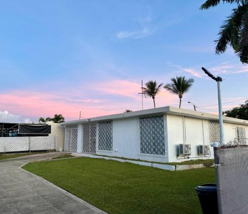 un edificio blanco con palmeras en el fondo en Casa ValeAna Peaceful house, en Sabana Abajo