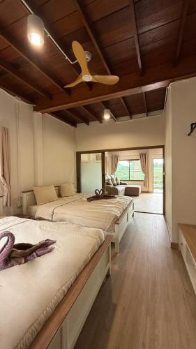 a bedroom with four beds and a ceiling fan at Kwainoy Riverpark in Sai Yok