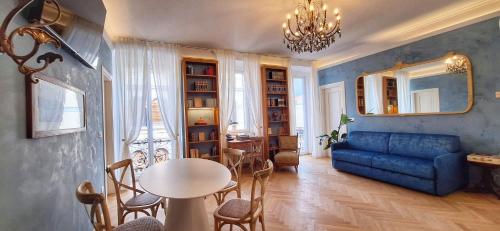 a living room with a blue couch and a table at Casa Saba Trieste Luxury Apartment with terrace in Trieste