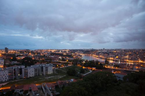 a city at night with a river and buildings at Douro View Apartment in Vila Nova de Gaia