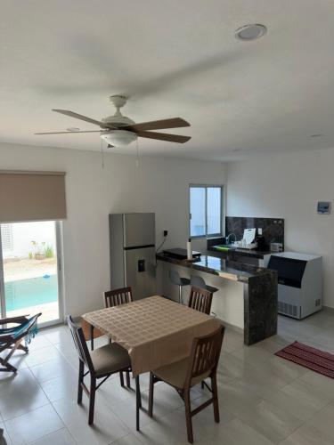 a kitchen and dining room with a table and a ceiling fan at Casa D'Sauza's in Tekax de Álvaro Obregón