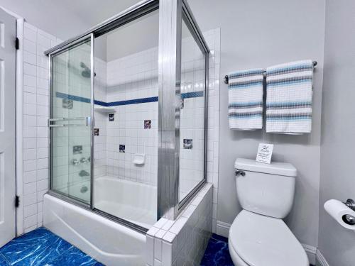 a white bathroom with a shower and a toilet at Destination #22 in Anaheim