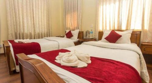a hotel room with two beds with towels on them at Hotel Norbu Sangpo in Kathmandu