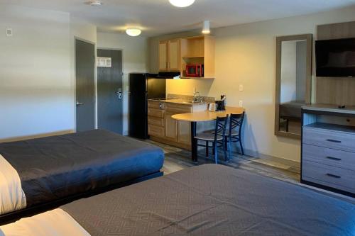 une chambre avec un lit et une cuisine avec une table dans l'établissement Suburban Studios near Panama City Beach, à Panama City